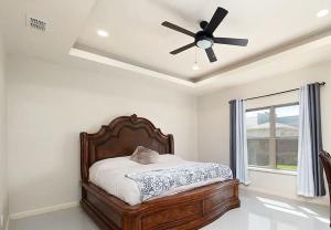 1 dormitorio con 1 cama y ventilador de techo en The Oasis- Sleeps 8 (Brownsville, SPI, SpaceX), en Brownsville