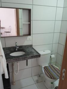 a bathroom with a toilet and a sink and a mirror at Vizinho ao Shopping Caruaru Cobertura 14 andar in Caruaru