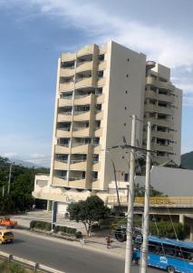 un gran edificio blanco con un autobús delante en Apartamento Santa Marta 405, en Santa Marta