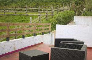 un patio con 2 panche nere e una recinzione di Encosta Serra Lagoa do Fogo 1/4 da Casa Do Monte a Vila Franca do Campo