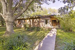 a wooden house with a tree in the yard at Mid-Century Hideaway Spacious Brownsville Home! in Brownsville