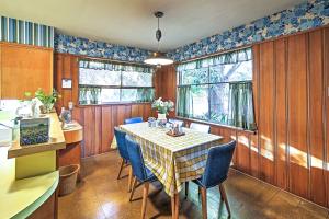 a dining room with a table and blue chairs at Mid-Century Brownsville Hideaway with Patio and Yard! in Brownsville