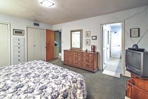 a bedroom with a bed and a television at Mid-Century Brownsville Hideaway with Patio and Yard! in Brownsville