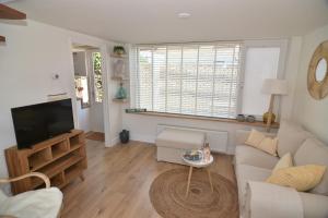 a living room with a couch and a tv at Casa Feliz in Egmond aan Zee