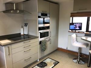 a kitchen with white cabinets and a stove top oven at Ye Olde Globe & Chequers in Huntingdon