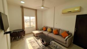 a living room with a couch and a television at هومينج - Homing (شقق مفروشة) in Salalah