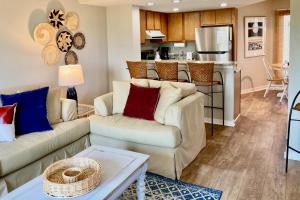 a living room with two couches and a kitchen at Port O'Call C-303 in Isle of Palms