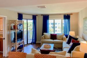 ein Wohnzimmer mit einem Sofa und einem TV in der Unterkunft Port O'Call C-303 in Isle of Palms