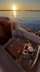 a boat with the sun setting on the water at Bed & Boat L' Isola che non c'è in Viareggio