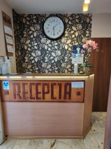 a clock on a wall above a reception desk at Vistula City in Płock