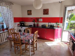 a kitchen with a table and chairs and a red counter at Vistula City in Płock