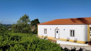 een wit huis met een rood dak bij Quinta do Oratório Agroturismo in Óbidos