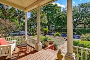 a wooden deck with a bench and a porch with trees at Island Charm1908 classic in the heart of downtown in Fernandina Beach