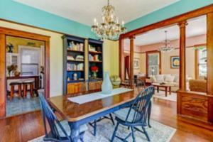 a dining room and living room with a table and chairs at Island Charm1908 classic in the heart of downtown in Fernandina Beach
