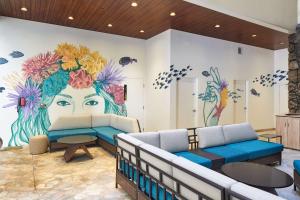a room with a mural of a woman with flowers on the wall at Waikiki Malia in Honolulu