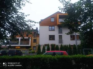 a red car parked in front of a building at Apartament Parkowy 24h in Łomża
