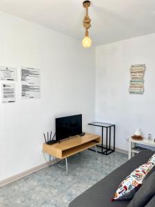 a room with a desk with a tv on a wall at Atte's house, Pozo Izquierdo in Pozo Izquierdo