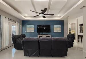 sala de estar con sofá y ventilador de techo en The Oasis- Sleeps 8 (Brownsville, SPI, SpaceX), en Brownsville