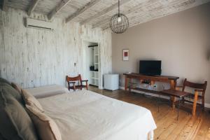 een slaapkamer met een bed, een bureau en een televisie bij Posada Las Aguas in Gualeguaychú