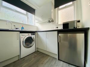 a kitchen with a washer and dryer in a room at Emerald Properties UK 4 bedrooms - Swansea City Centre, close to beaches! in Swansea