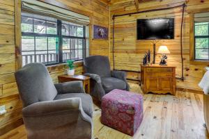 a living room with two chairs and a flat screen tv at Beaver Lake Vacation Rental with Private Hot Tub! in Eureka Springs