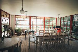 a dining room with a table and chairs and windows at Posada Las Aguas in Gualeguaychú