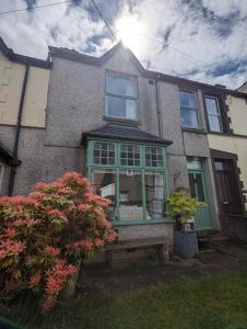 una casa con una ventana verde en la parte delantera en Perfect for Snowdon. Groups, families+dogs welcome en Llanberis