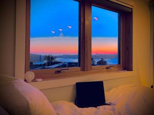 a bedroom with a window with a view of the sunset at Floien City House -free parking in Bergen +26 photos