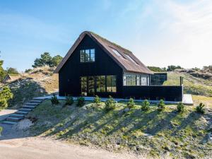ein schwarzes Haus mit einem Gameradach in der Unterkunft Holiday home Fanø XIV in Fanø