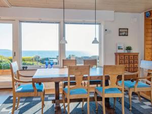 a dining room with a wooden table and chairs at Panoramic Water View - By Traum Ferienwohnungen in Børkop