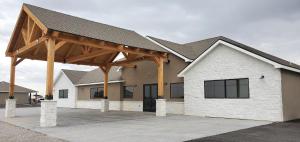 a large white building with a wooden roof at Longhorn Flats in Loving