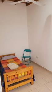 a bedroom with a wooden bed and a green chair at ARMONY in Patagones