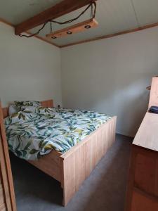 1 dormitorio con 1 cama con marco de madera en Natuurchalet de Das, en Wehl