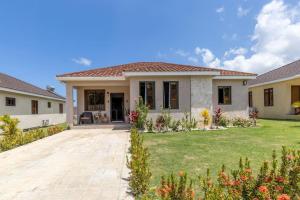 ein Haus mit Rasen davor in der Unterkunft Sun Shine Luxury Villas 2 bedroom Pool & Gym Ocho Rios St Ann in Ocho Rios