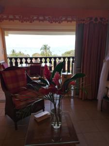 a living room with a vase with flowers on a table at Bigouz résidence la plage de l'anse Caritan in Sainte-Anne