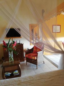 un soggiorno con tavolo e sedia rossa di Bigouz résidence la plage de l'anse Caritan a Sainte-Anne