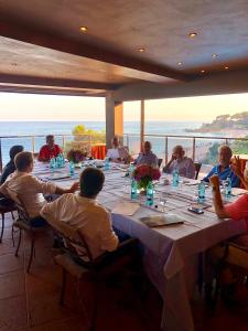 a group of people sitting around a long table at Rigat Park & Spa Hotel - Adults Recommended in Lloret de Mar
