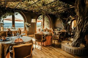 a restaurant with tables and chairs and a tree at Rigat Park & Spa Hotel - Adults Recommended in Lloret de Mar