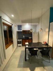 a kitchen with a black dining table and chairs at Pousada Arraial Charme in Arraial d'Ajuda