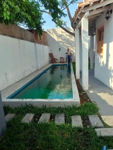 Ein Mann steht neben einem Pool neben einem Haus. in der Unterkunft Casa La Escondida Tlacotalpan in Tlacotalpan