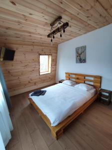 Mountain Break Azuga في أَزوغا: غرفة نوم بسرير كبير في غرفة خشبية