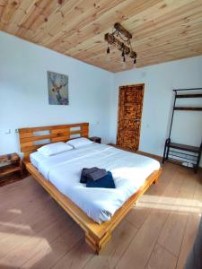 1 dormitorio con 1 cama grande y techo de madera en Mountain Break Azuga, en Azuga