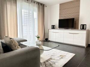 sala de estar con sofá y TV en Appartement T2 vue panoramique sur Annecy en Seynod