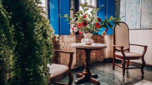 stół z wazonem kwiatów i dwoma krzesłami w obiekcie Pousada Mucugê w mieście Mucugê