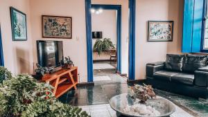 Pousada Mucugê في موسوجي: غرفة معيشة مع أريكة وتلفزيون