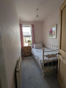 a small bedroom with a bed and a window at Perfect for Snowdon. Groups, families+dogs welcome in Llanberis