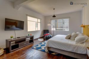 een slaapkamer met een bed en een flatscreen-tv bij Refurbished Mansion with Garden & Patio in Las Lomas - Monte Blanco in Mexico-Stad
