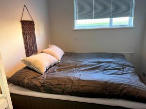 a bed in a bedroom with a pillow on it at Lovely Apartment with 2-bedrooms and living room for 4 guests, max 6 - Seaside Neighborhood in Reykjavík