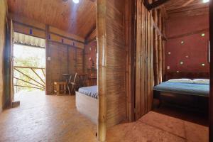 1 dormitorio con 1 cama en una habitación de madera en Cambuca Surf Skate, en Ubatuba