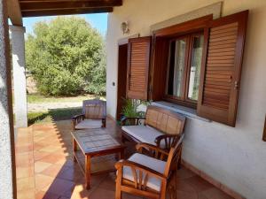 a porch with chairs and a table and a window at La CASA del CUORE PULA in Pula